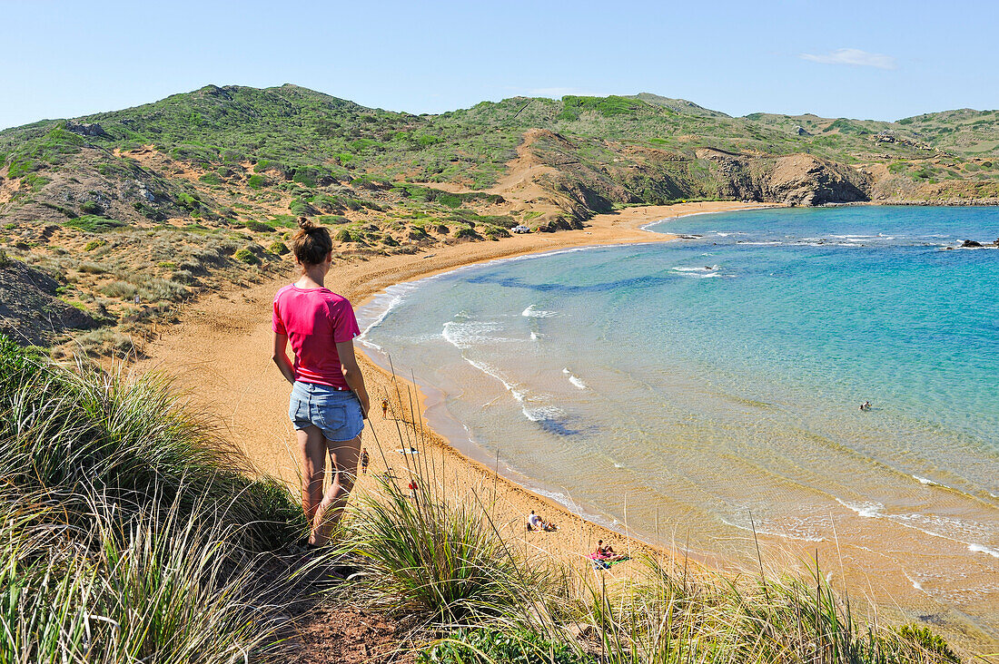 young woman admiring the Cavalleria Beach at Cape Cavalleria on the North Coast of Menorca, Balearic Islands, Spain, Europe