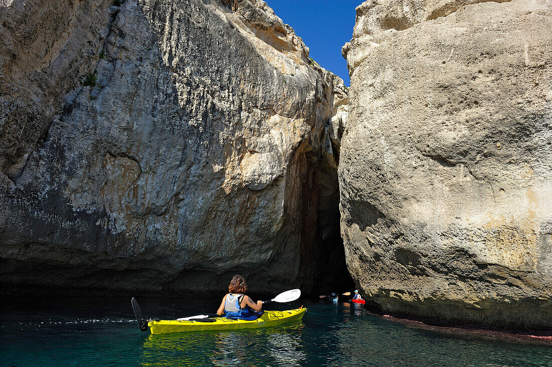 Kajak vor Klippen und Felsenhöhle in der Nähe von Cala Galdana, Südküste von Insel Menorca, Balearen, Spanien, Europa