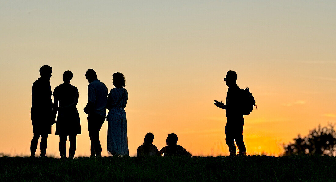  Silhouette of a group of people at sunset in the Olympic Park in Munich in July 2024 