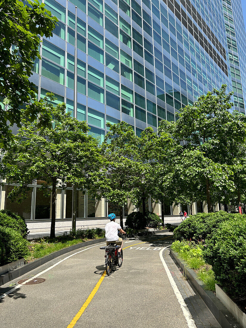 Cyclist on bicycle path alongside Goldman Sachs Global Headquarters, 200 West Street, New York City, New York, USA