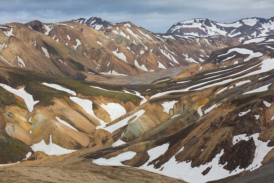  Colourful rhyolite mountains with snow residues at Blahnukur volcano in Landmannalaugar, Fjallabak National Park, Sudurland, Iceland 