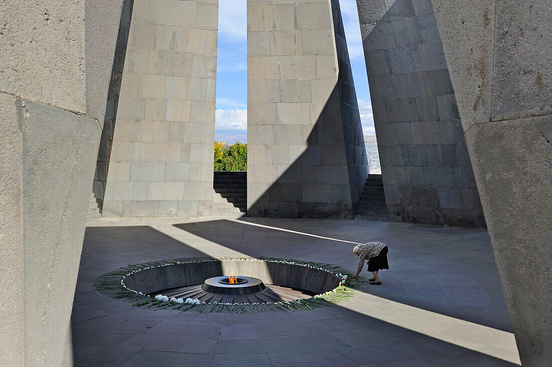  Moment der Ehrfurcht vor der ewigen Flamme im Zentrum der zwölf Granitplatten des Gedenkkomplexes für den Völkermord an den Armeniern auf dem Hügel von Zizernakaberd in Jerewan, Armenien, Eurasien 