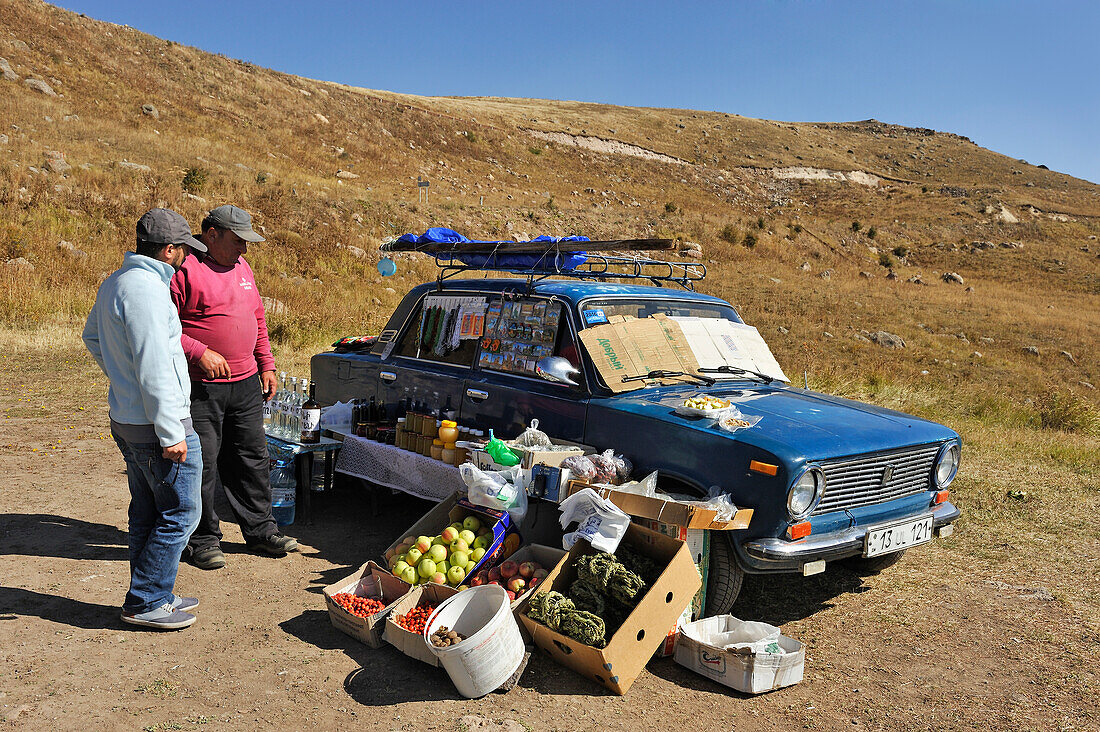 fruits and local products vendor in front of Orbelian's Caravanserai or Selim Caravanserai at Vardenyats Mountain Pass, previously Selim Mountain Pass, near Yeghegnadzor, Gegharkunik province, Armenia, Eurasia