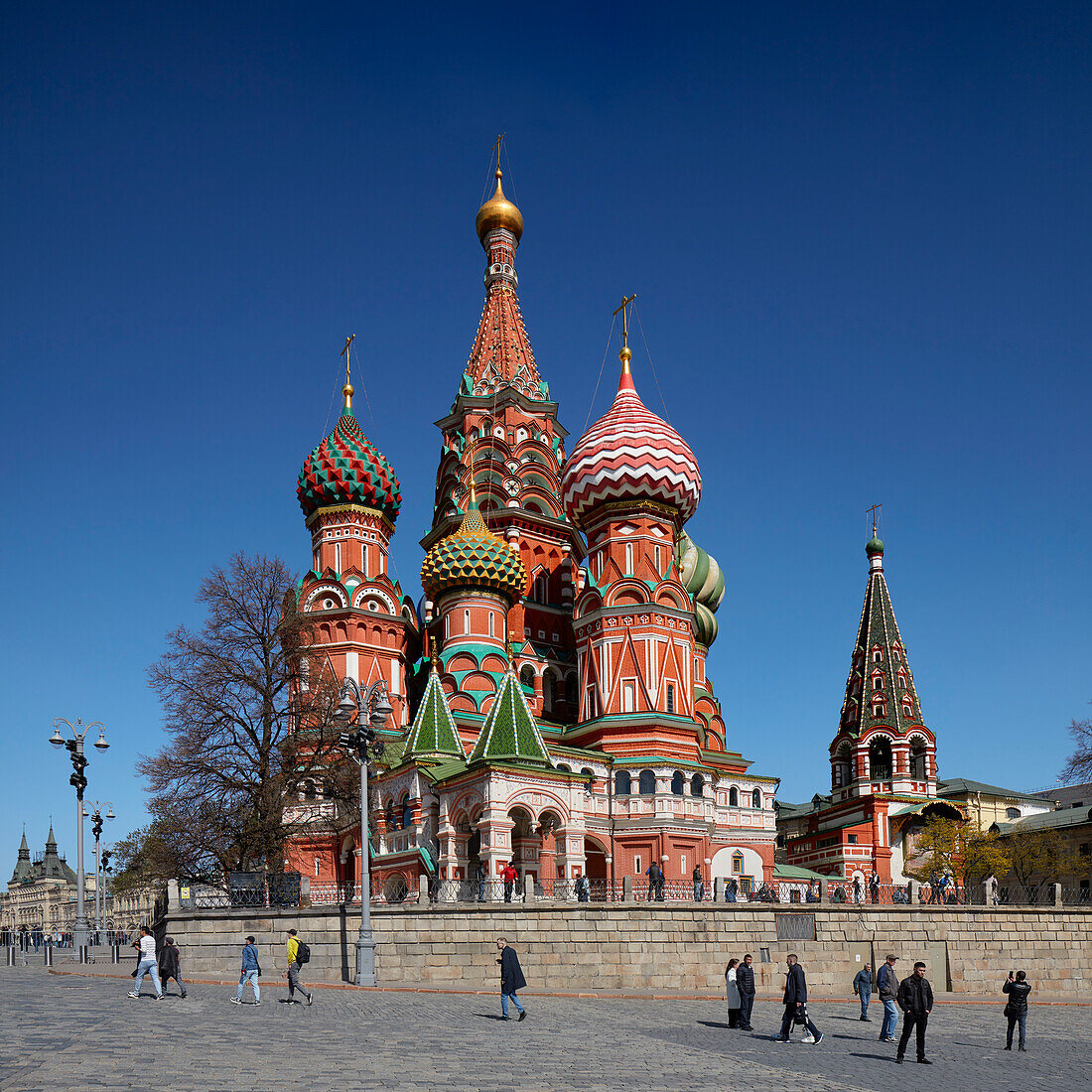 People walk in front of the 16th century Cathedral of Vasily the Blessed, aka Saint Basil's Cathedral. Red Square, Moscow, Russian Federation.