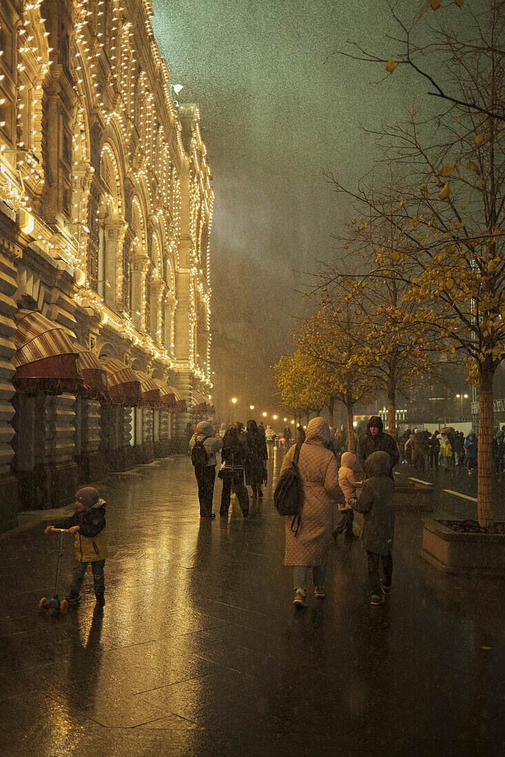 People walk in the Red Square during a sudden snowstorm at night. Moscow, Russia.