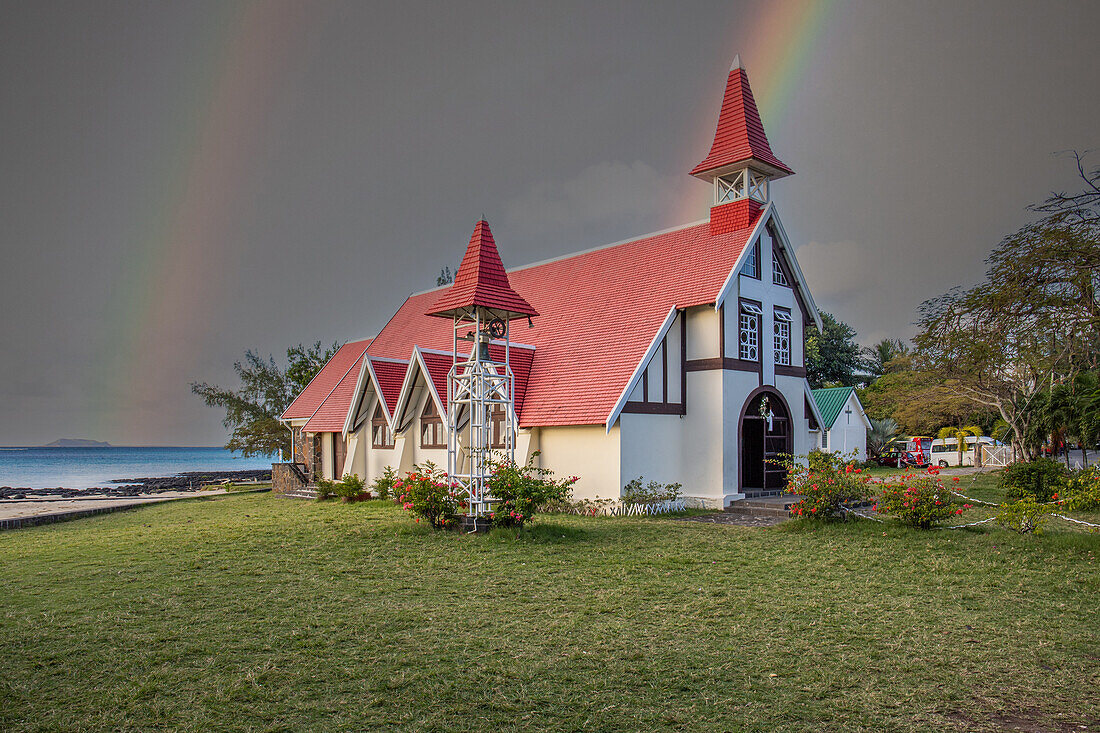  Notre-Dame Auxiliatrice de Cap Malheureux, church with red roof directly by the sea and Mauritius at sunset 