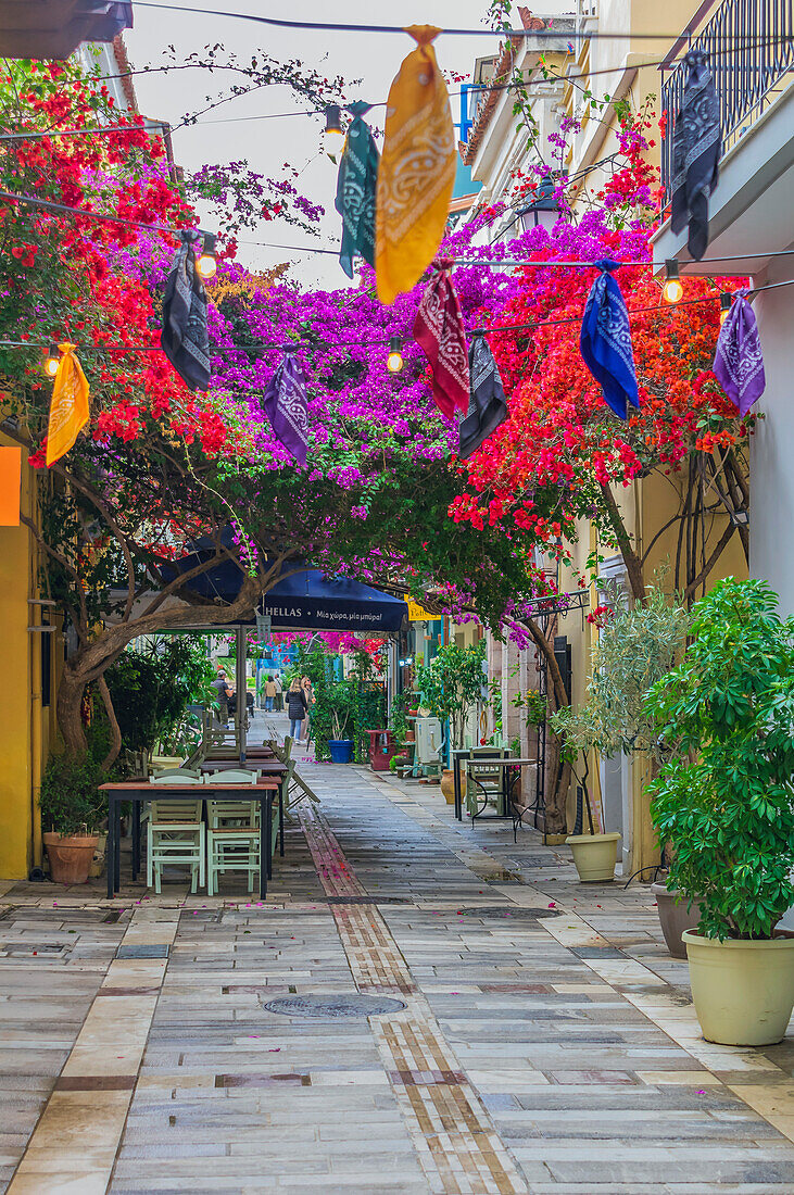 Gassen mit Straßencafes, bunten Tüchern und blühenden Bougainvilleas, in der Stadt Nafplio, Peloponnes, Argolischer Golf, Ägäis, Griechenland