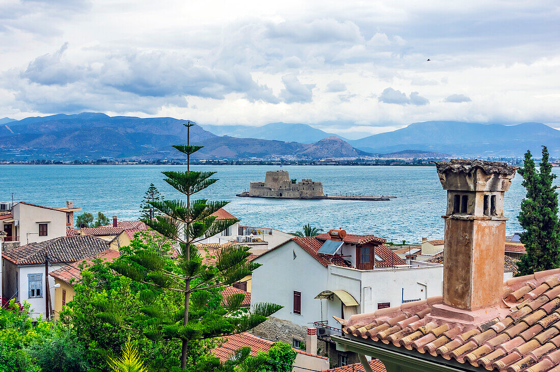  View of houses of the city of Nafplio with the fortress of Bourtzi in the background, Peloponnese, Greece 