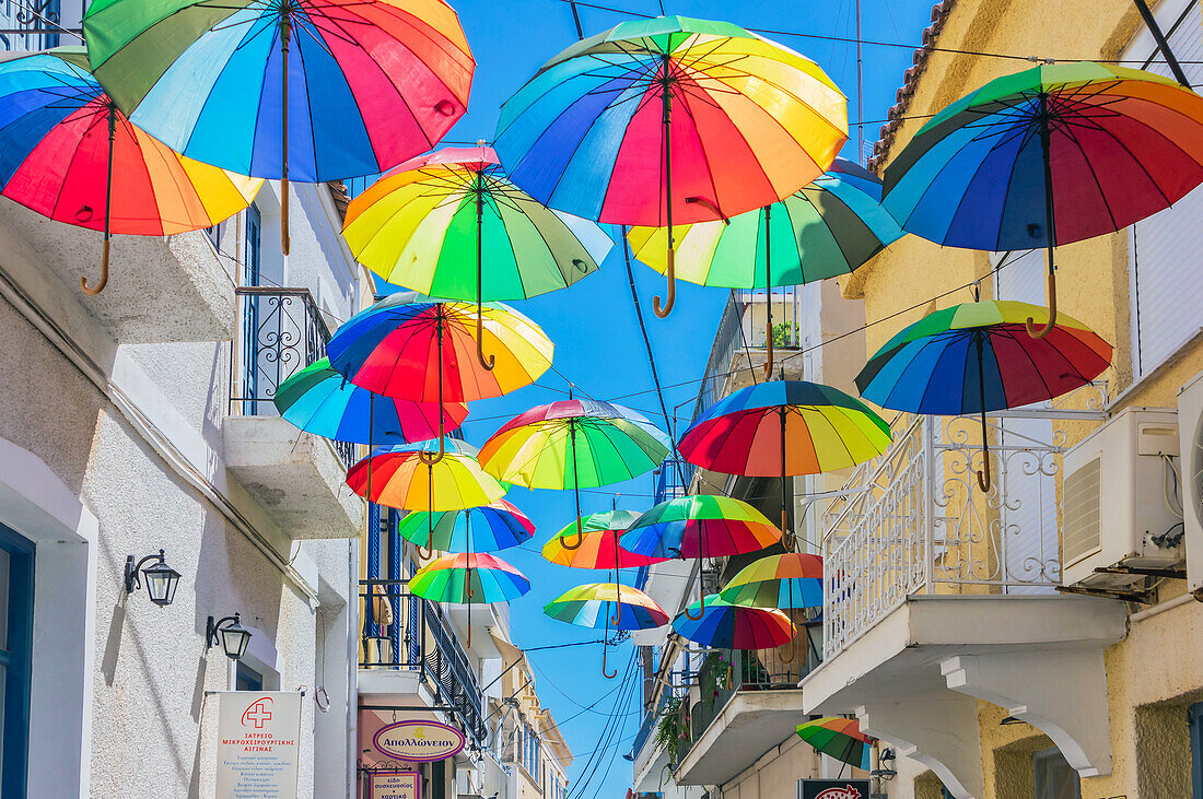  Aegina is a Greek island in the Saronic Gulf in the western Aegean Sea, also called the Gulf of Aegina. The island is located 25 km southwest of Athens. Here a street with colorful umbrellas 