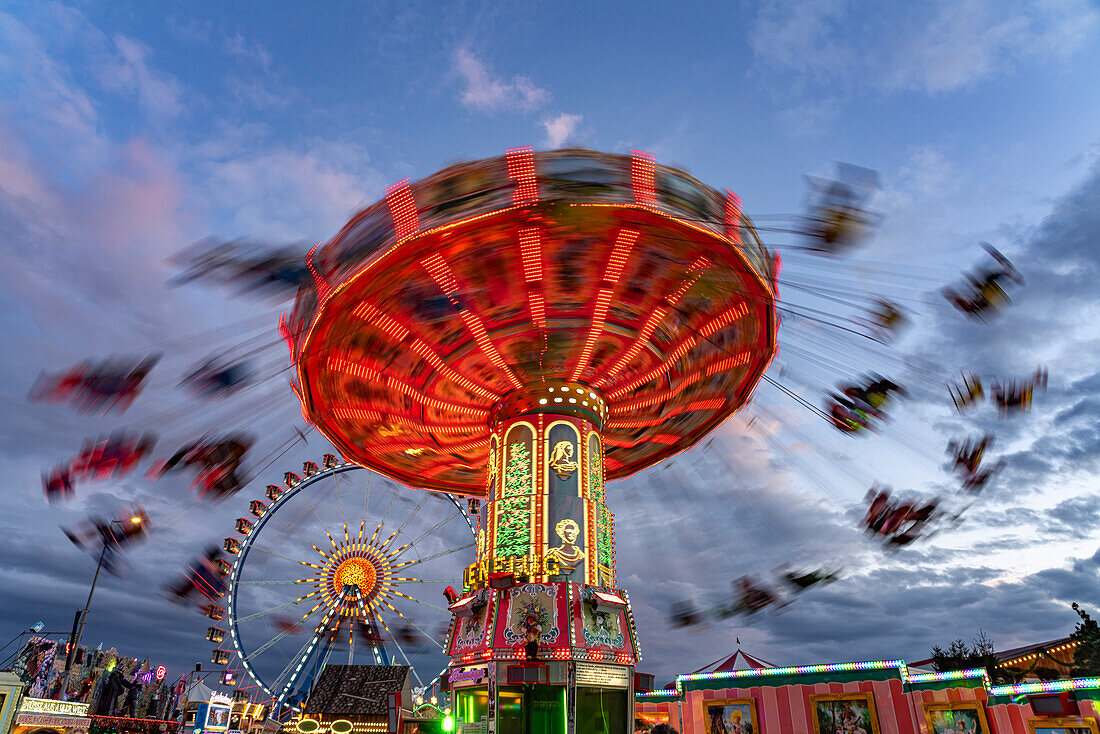 Kettenkarussell beim Oktoberfest in der Abenddämmerung, München, Bayern, Deutschland