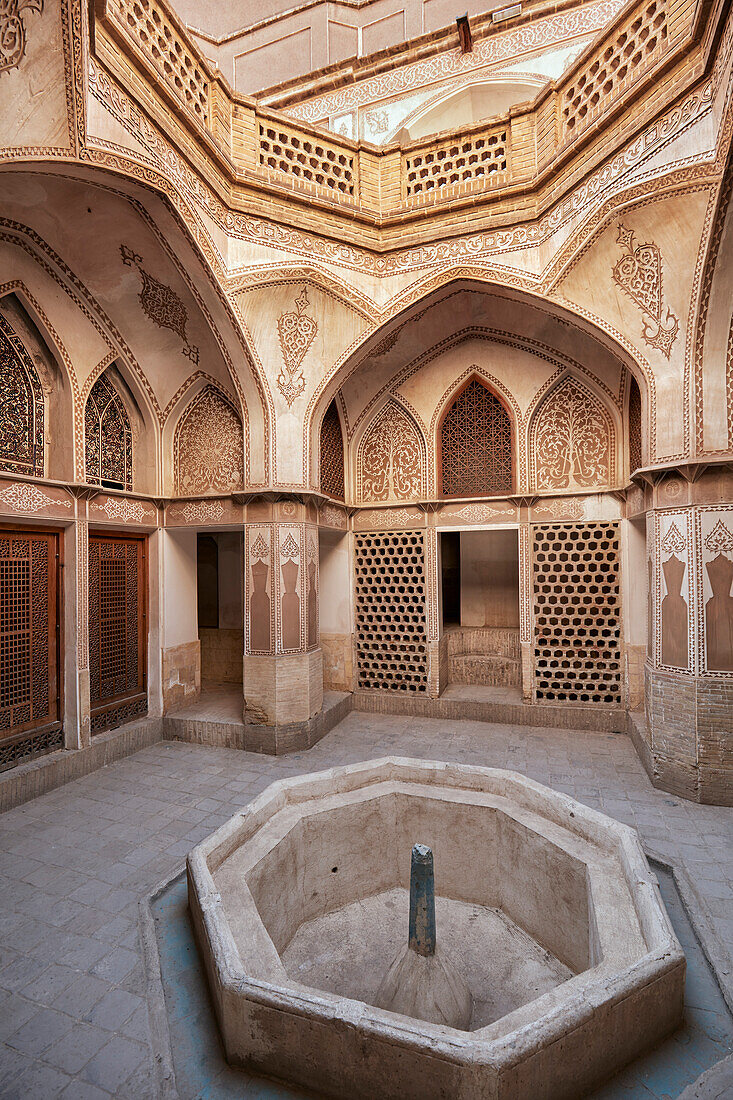  Kleiner Innenhof mit trockenem Brunnenbecken im Abbasi-Haus, einem traditionellen, reich verzierten persischen Haus aus dem Jahr 1823. Kashan, Iran. 