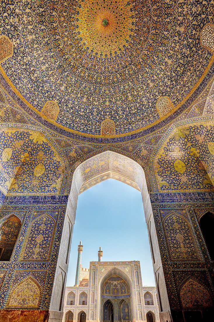 Courtyard view of the Shah Mosque (Masjed-e Shah) from the main prayer hall with its ornate tiled ceiling. Isfahan, Iran.