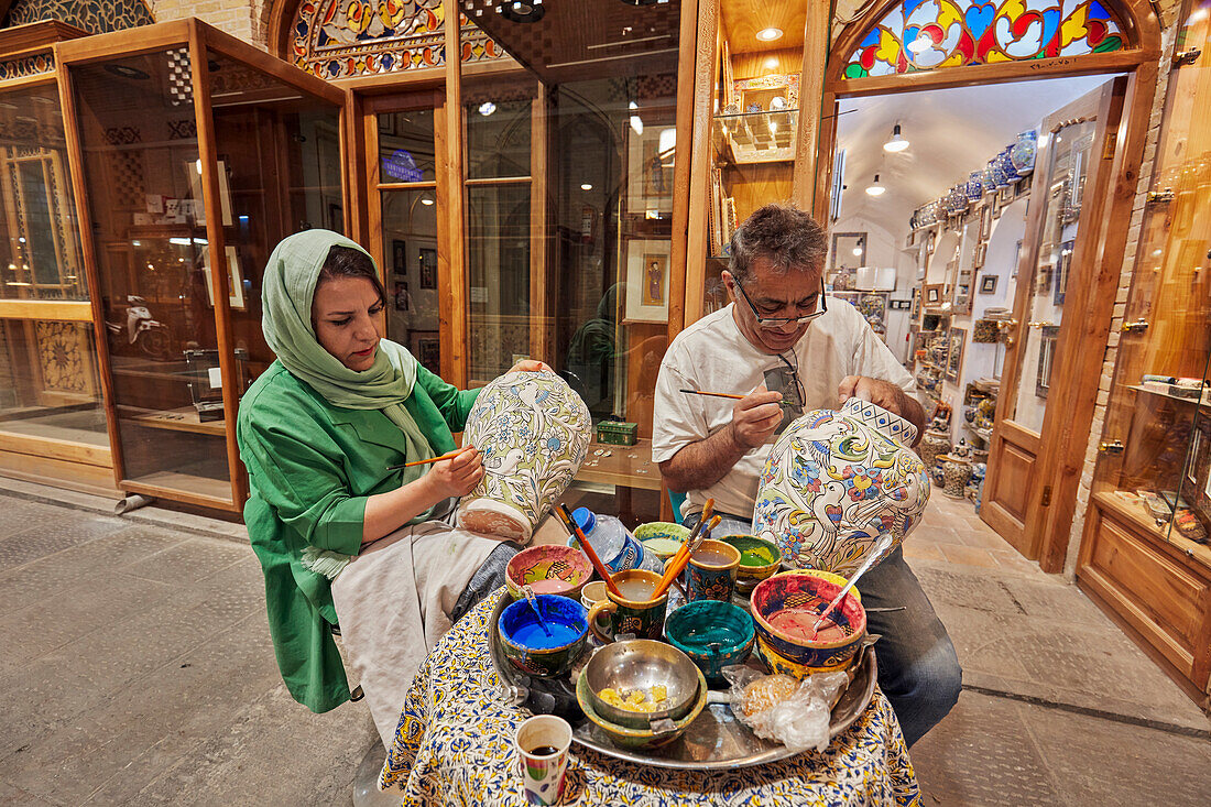  Iranische Kunsthandwerker bemalen große Keramiktöpfe von Hand vor der endgültigen Glasur. Großer Basar, Isfahan, Iran. 