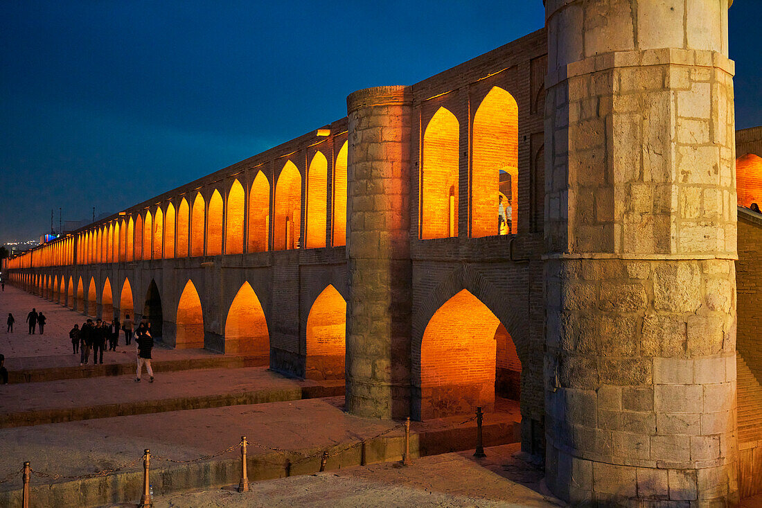  Blick auf die beleuchtete Allahverdi Khan-Brücke, auch bekannt als Si-o-se-pol (17. Jahrhundert), am Zayanderud-Fluss während der Trockenzeit mit trockenem Flussbett. Isfahan, Iran. 