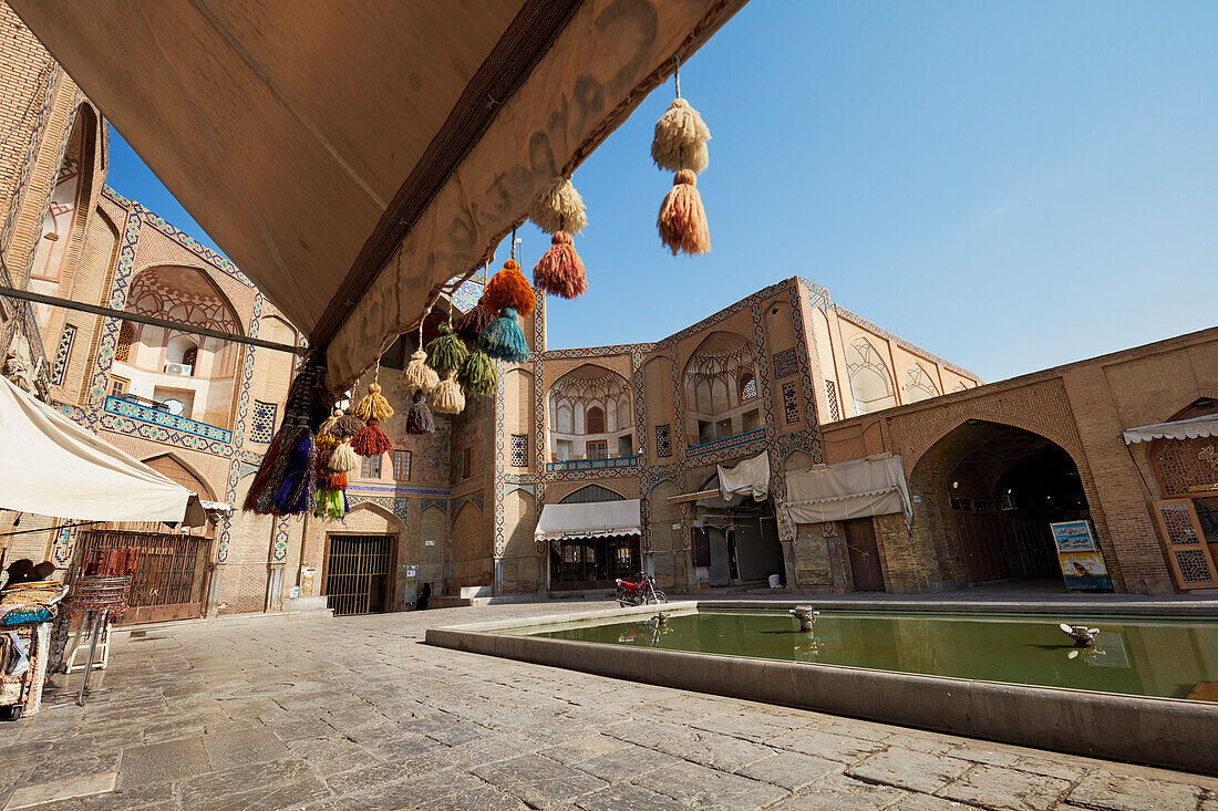 View of a small plaza with water pool at the Qeysarie Gate, the main gateway to the Grand Bazaar of Isfahan in Naqsh-e Jahan Square. Isfahan, Iran.