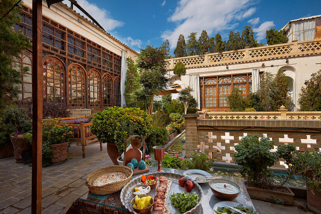 Hühnchen-Kebab mit Gemüse und Fladenbrot, serviert in einem traditionellen iranischen Restaurant auf der Terrasse eines gehobenen Hotels. Isfahan, Iran.