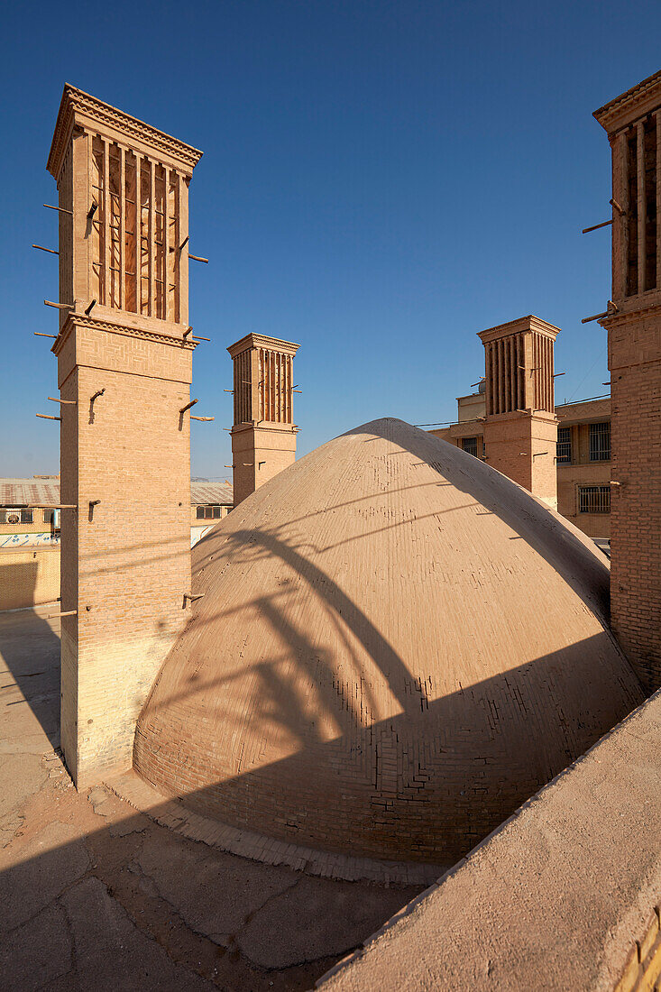 Kuppeldach und Windfänger (traditionelle Türme zur Querlüftung und passiven Kühlung) des alten Golshan-Wasserreservoir in Yazd, Iran.