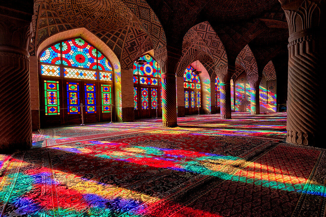 A play of light from multi-colored stained-glass windows inside the 19th century Nasir al-Mulk Mosque, aka the Pink Mosque. Shiraz, Iran.