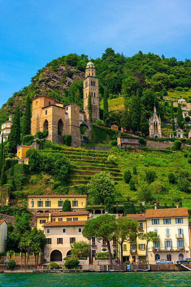 Haus und Kirche auf einer Bergkette an einem sonnigen Sommertag am Ufer, Luganersee in Morcote, Lugano, Tessin, Schweiz.