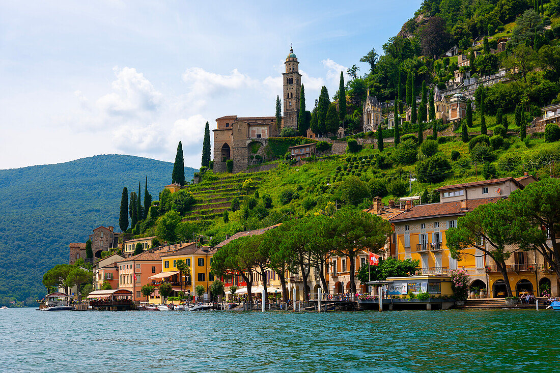 Haus und Kirche auf einer Bergkette an einem sonnigen Sommertag am Ufer, Luganersee in Morcote, Lugano, Tessin, Schweiz.