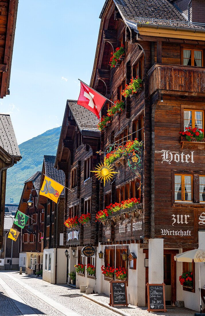 Beautiful City Street in Old Town with Houses and Hotel and with Mountain in a Sunny Summer Day in Andermatt, Uri, Switzerland.