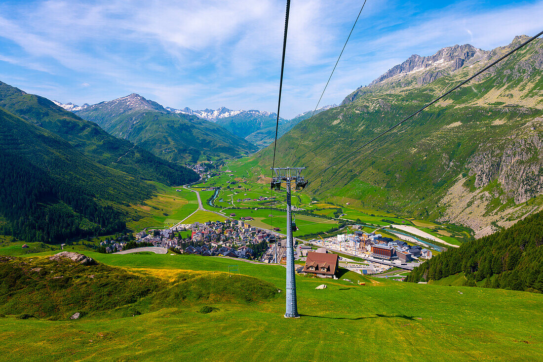 Beautiful Panoramic View From Overhead Cable Car over New and Old Cityscape and Golf Course with Mountainscape and Mountain Valley in a Sunny Summer Day in Andermatt, Uri, Switzerland.