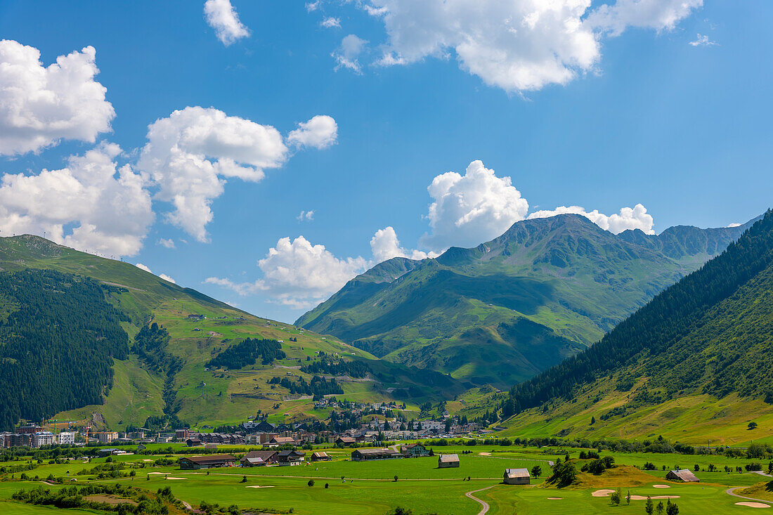 Panoramablick über den Golfplatz mit Berglandschaft und Gebirgstal an einem sonnigen Sommertag in Andermatt, Uri, Schweiz.