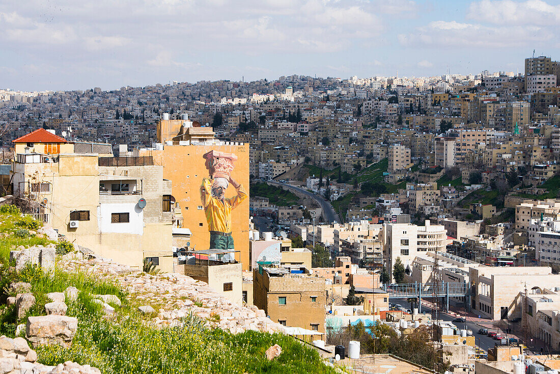 View from the top of the hill of the Citadel on the mural "The Column" (artists: Jofre Oliveiras and Dalal Mitwally) and the eastern districts of Amman, Jordan, Near East, Southern Levant, West Asia