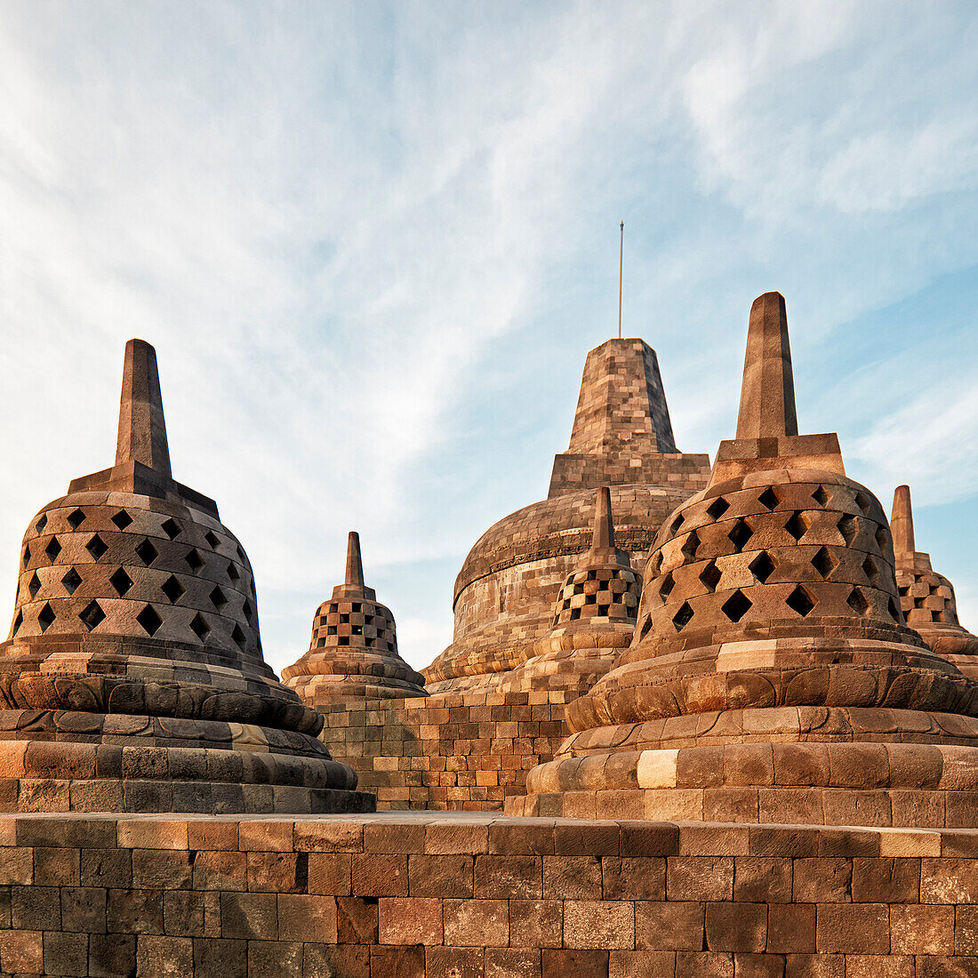 Rhombus holed and square holed stupas and the main top stupa in the Borobudur, 9th-century Buddhist temple. Magelang Regency, Java, Indonesia.