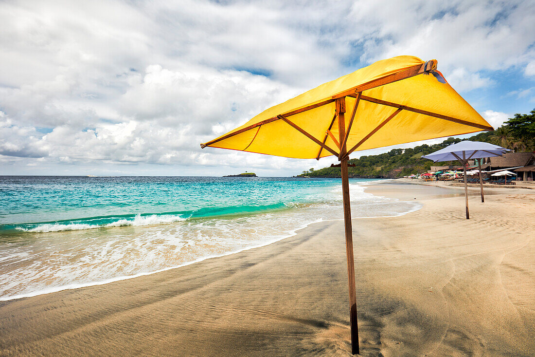 Gelber Sonnenschirm am White Sand Beach (Pantai Bias Putih). Manggis, Regentschaft Karangasem, Bali, Indonesien.