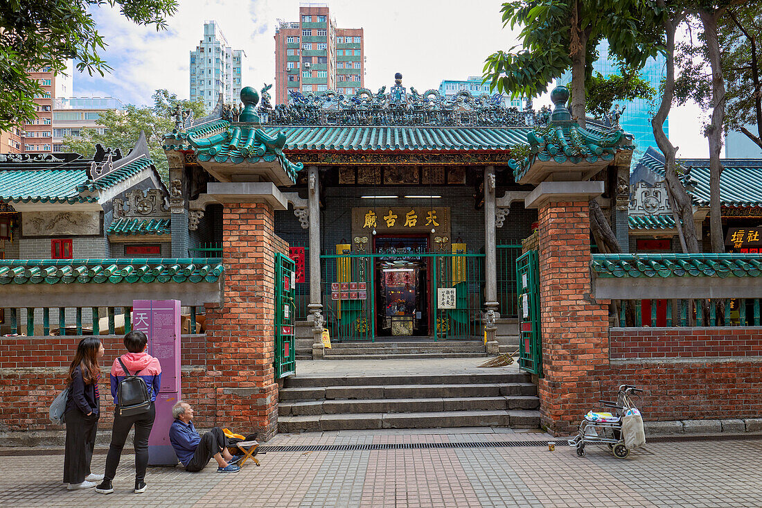  Touristen schauen sich den Informationsstand am Eingang zum Tin Hau-Tempelkomplex an. Yau Ma Tei, Kowloon, Hongkong, China. 