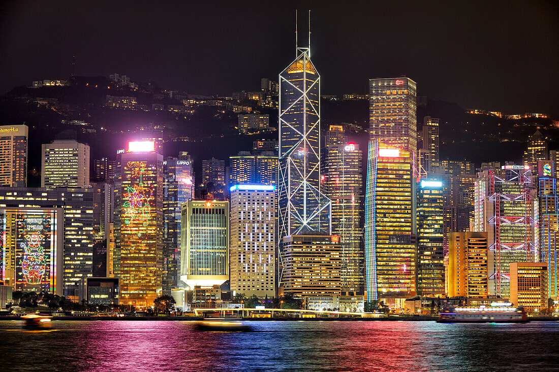 Modern high-rise buildings at Central Waterfront illuminated at night. Hong Kong, China.