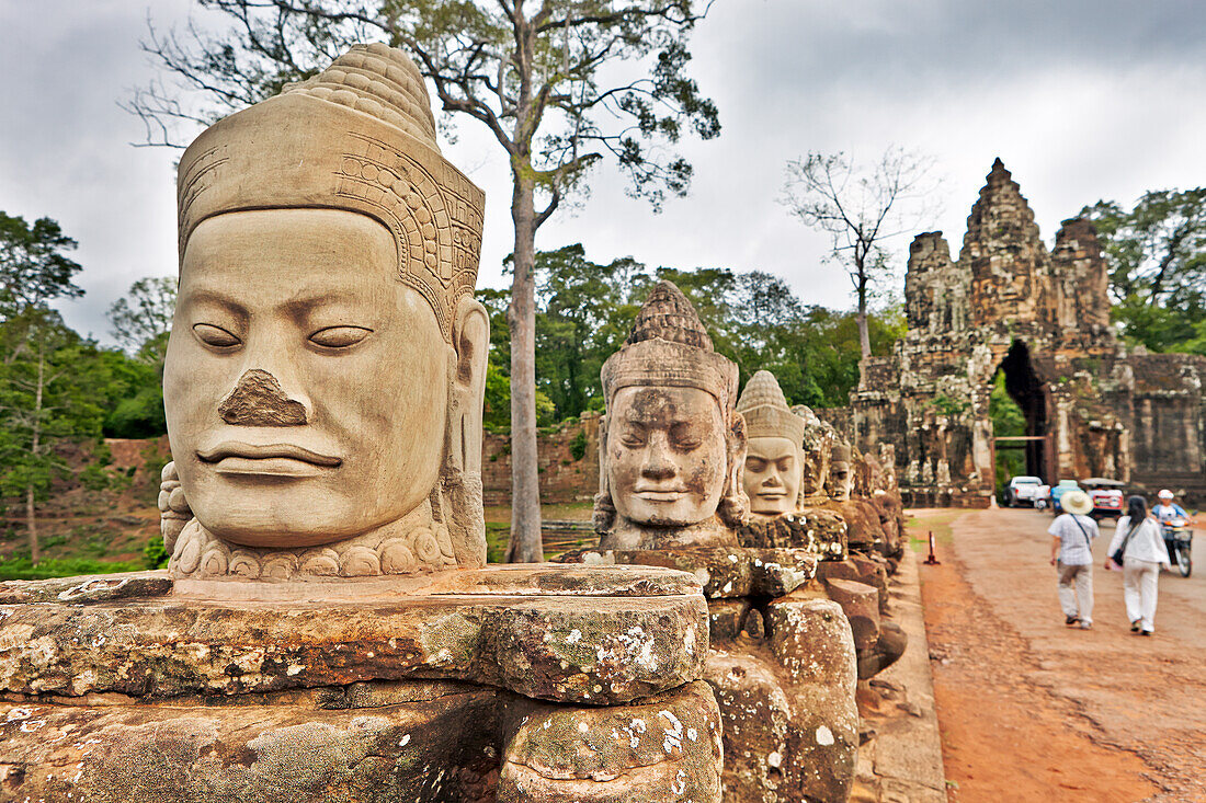 Large carved stone figures at the South Gate to the Angkor Thom. Angkor Archaeological Park, Siem Reap Province, Cambodia.