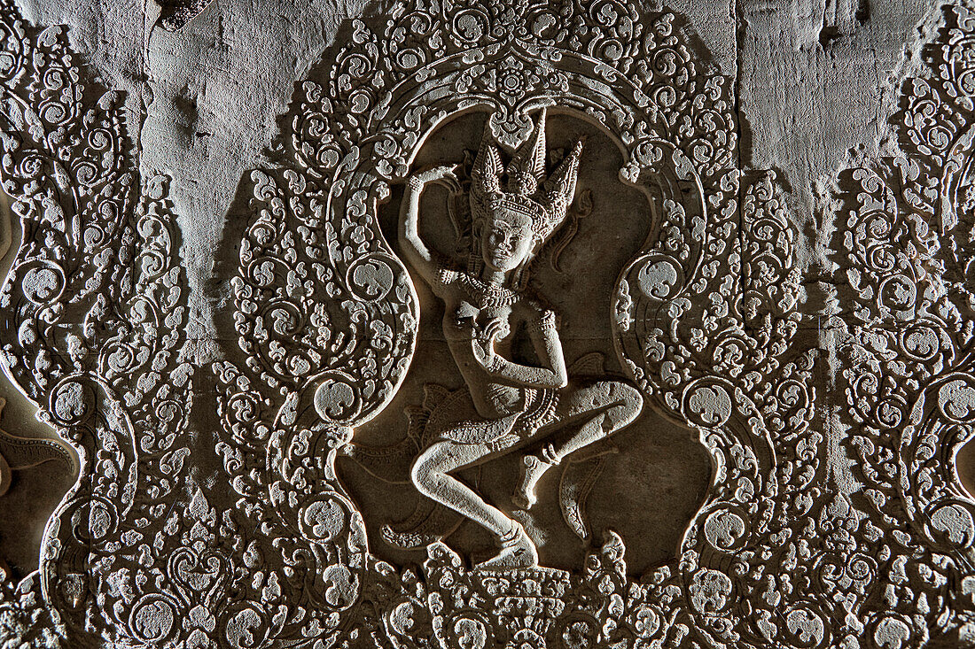 Intricate bas-relief of a dancing apsara (celestial dancer) in Angkor Wat temple complex. Angkor Archaeological Park, Siem Reap Province, Cambodia.