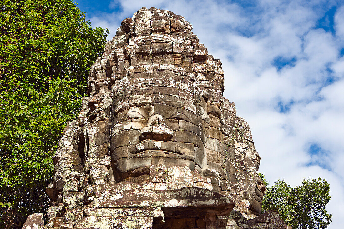 A giant stone carved face in the ancient Banteay Kdei temple. Angkor Archaeological Park, Siem Reap Province, Cambodia.