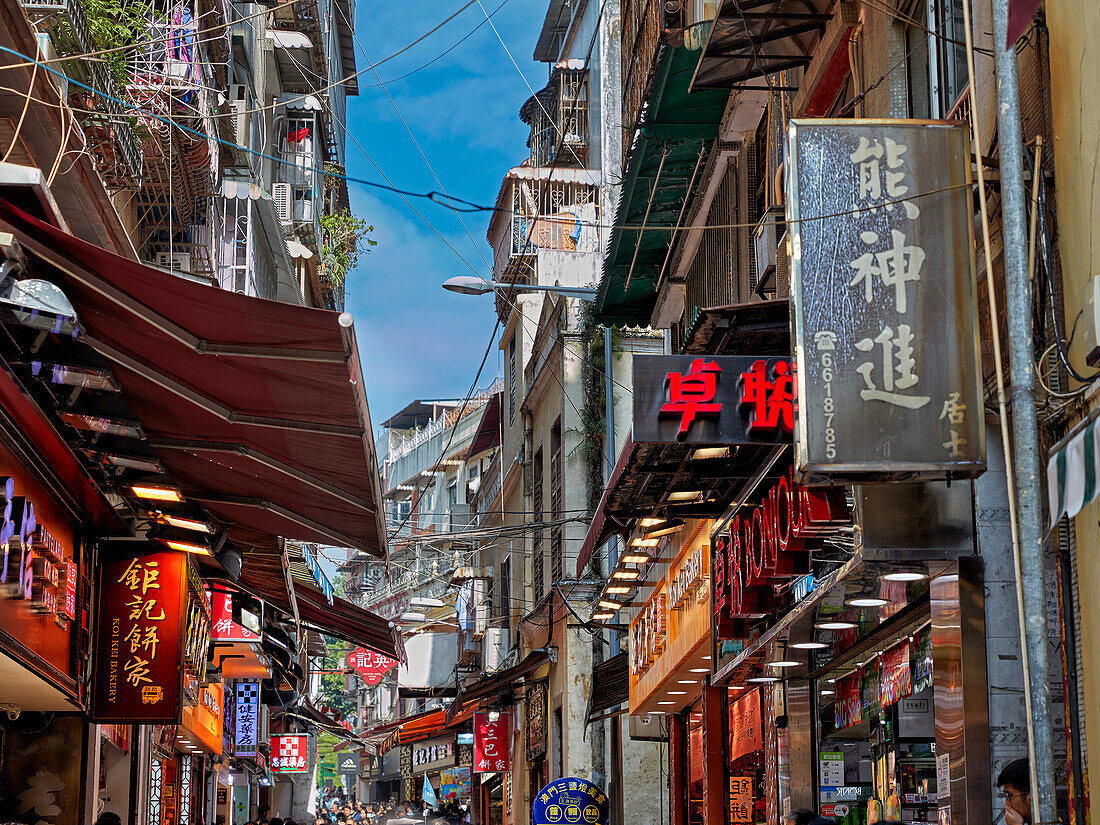 Old houses with multiple shops on Rua de S. Paulo, a narrow pedestrian street leading to the Ruins of Saint Paul's. Macau, China.