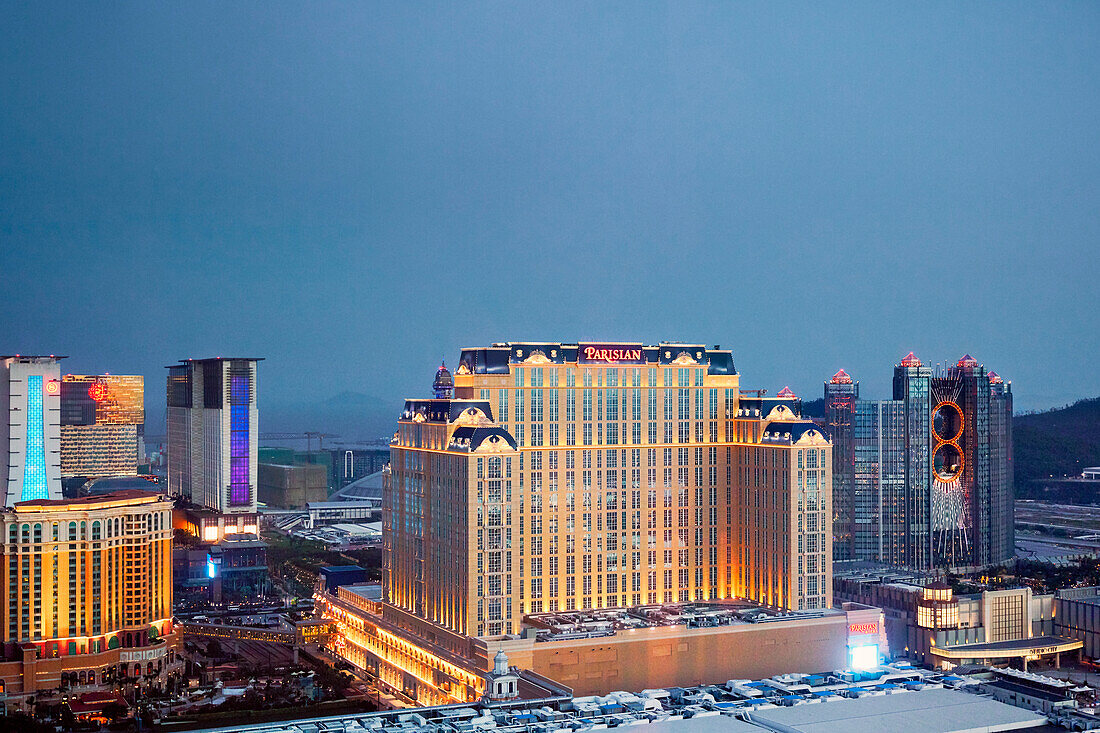 Aerial view of the Parisian Macao Hotel and surrounding buildings illuminated at night. Cotai, Macau, China.