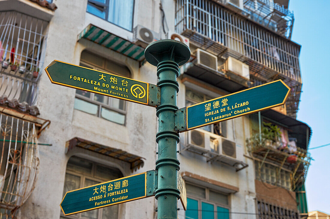 Pole with direction signs to the Mount Fortress and other attractions in the historic centre of Macau city, China.