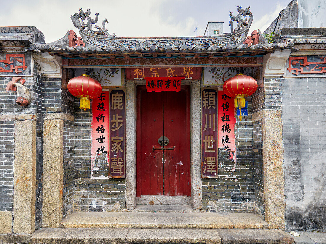 Close up view of an old house entrance door with red lanterns in Dafen Oil Painting Village. Shenzhen, Guangdong Province, China.