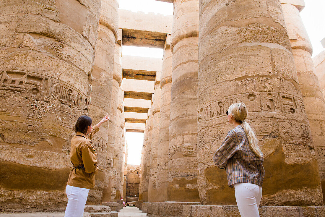 Junge Frauen in der großen Hypostyle-Halle im Bezirk Amon-Re, Karnak-Tempel-Komplex, Luxor, Ägypten, Nordostafrika