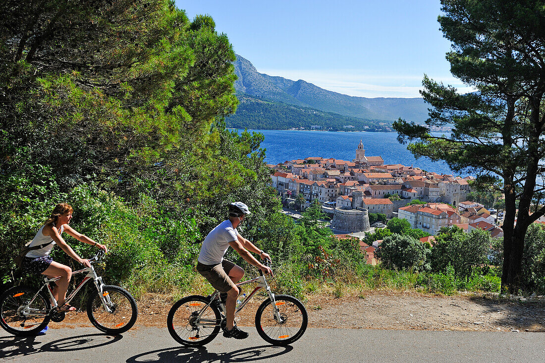 couple of cyclists in Korcula old town heights, Korcula island, Croatia, Southeast Europe