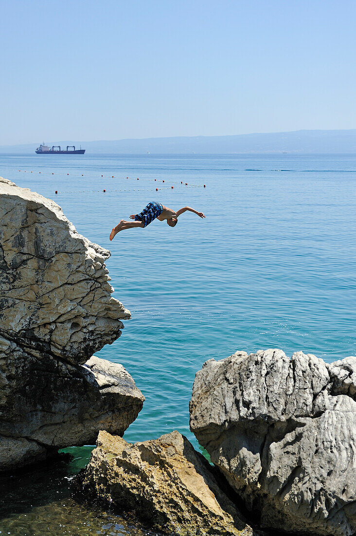 Jugendliche springen von Felsen ins Meer, beim Strand Jezinac am Fuße des Hügels Marjane, Split, Dalmatien, Kroatien, Südosteuropa