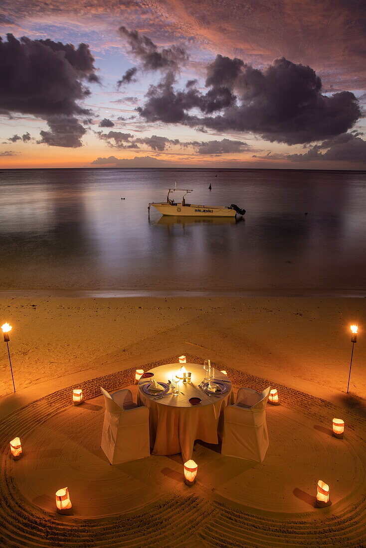  Table and chairs for a romantic candlelight dinner on the beach at Trou aux Biches Beachcomber Golf Resort 