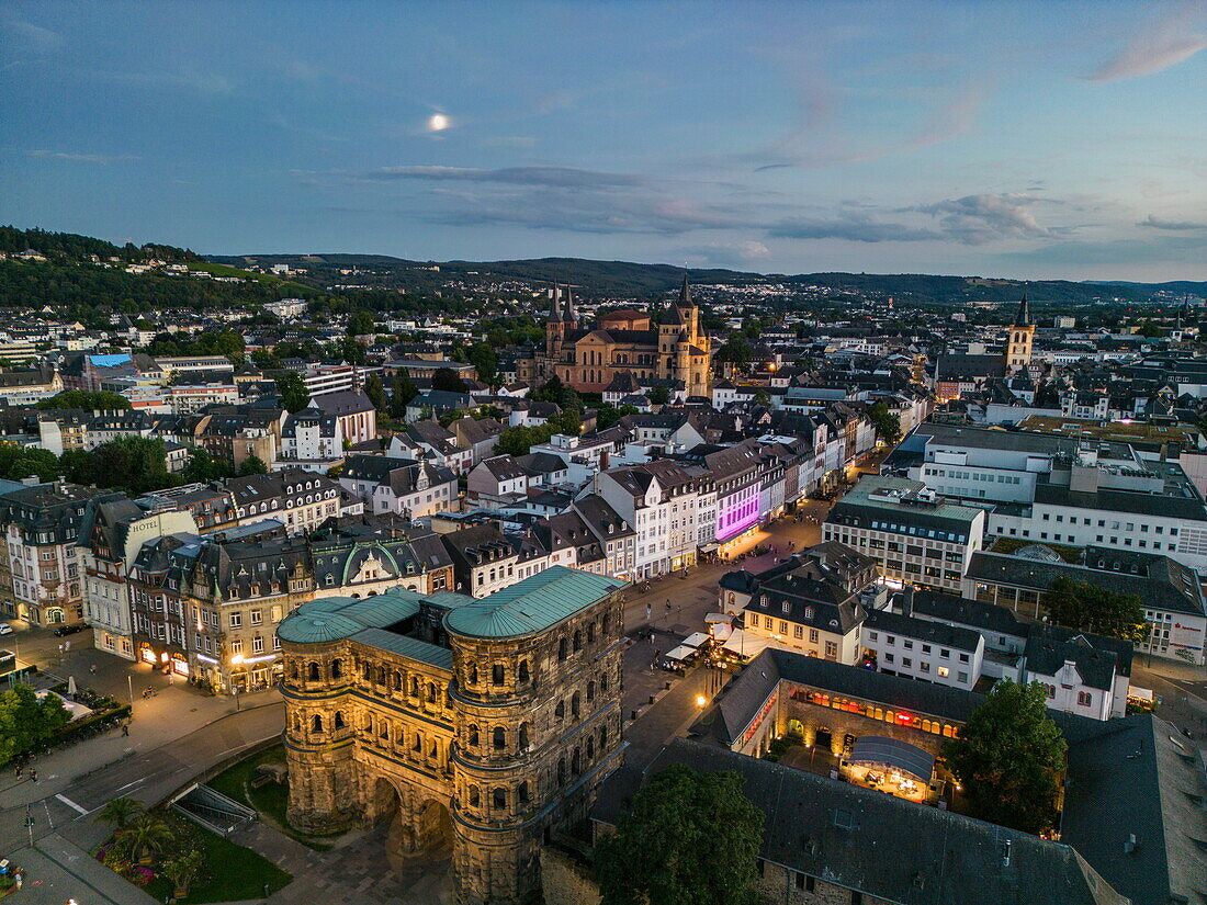 Luftaufnahme des römischen Stadttors Porta Nigra und der Stadt mit Vollmond in der Abenddämmerung, Trier, Rheinland-Pfalz, Deutschland, Europa