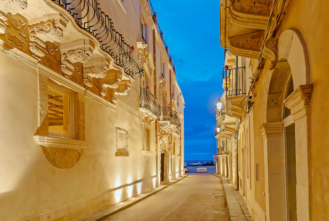  Historisches Viertel mit traditionellen Gebäuden, beleuchtet in der Abenddämmerung, Ortygia, Syrakus, Sizilien, Italien 