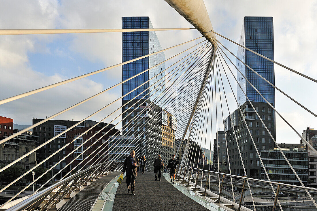 die Zubizuri, eine Fußgängerbrücke über den Fluss Nervión, mit den Zwillingstürmen Isozaki Atea im Hintergrund, Bilbao, Provinz Biscaya, Baskenland, Spanien, Europa