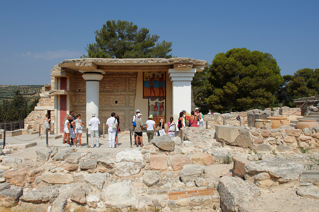  Besucher betrachten das Prozessionsfresko im Südpropylaeum im Palast von Knossos, das eine antike zeremonielle Kultprozession zeigt. Kreta, Griechenland. 