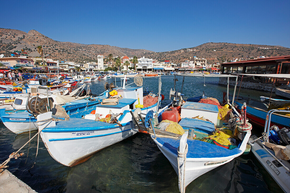 Traditional fishing boats moored in Elounda village harbour. Crete, Greece.