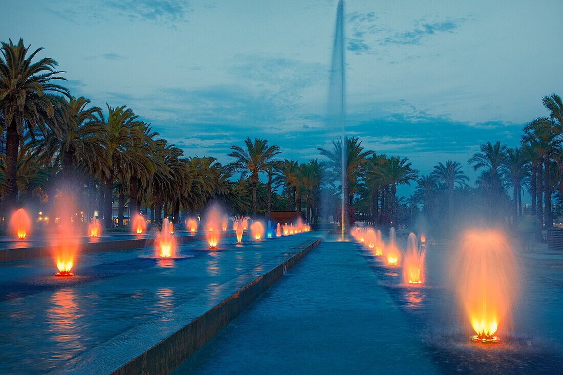  Farbige Wasserfontänen in der Straße Passeig de Jaume I, nachts beleuchtet. Salou, Katalonien, Spanien. 