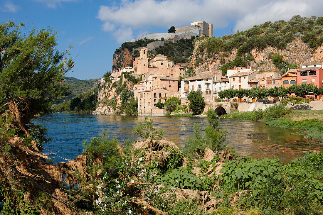  Malerische Aussicht auf das Dorf und die Burg von Miravet vom Fluss Ebro aus. Katalonien, Spanien. 